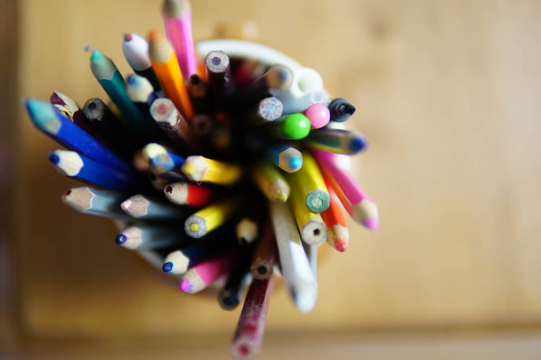 Crayons de couleur dans un verre en terre cuite
 - Photo, image