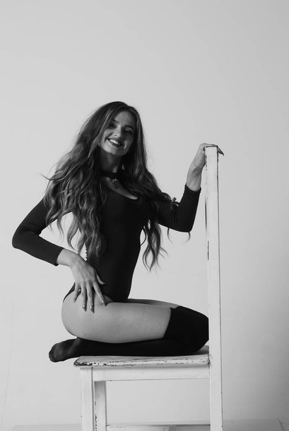 Young happy fitness girl with sporty body posing at studio on a  - Φωτογραφία, εικόνα