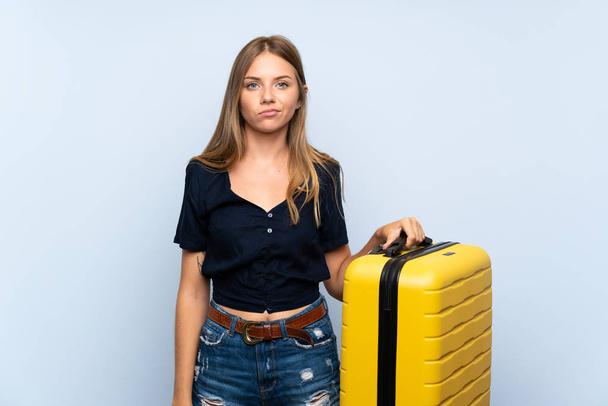 Traveler blonde woman with suitcase with sad expression - Foto, Bild