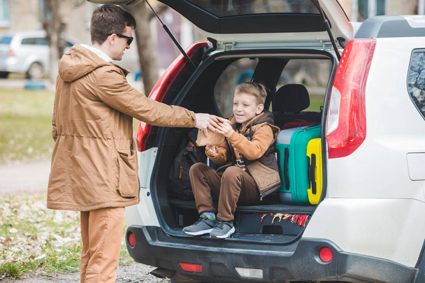 батько з сином упаковки мішків для багажника автомобіля. концепція подорожей автомобілем
 - Фото, зображення