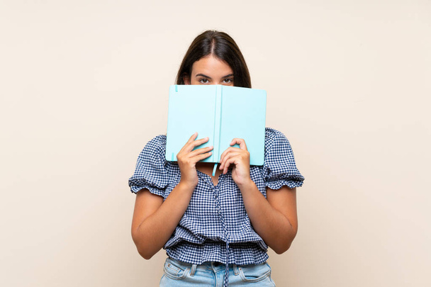 junges Mädchen mit isoliertem Hintergrund, das ein Buch hält und liest - Foto, Bild