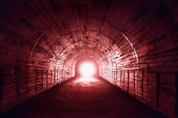 Rotlicht am Ende eines verlassenen unterirdischen Militärkorridors oder Tunnels, gruseliger Horror oder Thriller und Konzept der Angststimmung - Foto, Bild