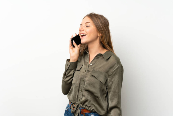 Chica rubia lituana sobre fondo blanco aislado manteniendo una conversación con el teléfono móvil
 - Foto, imagen
