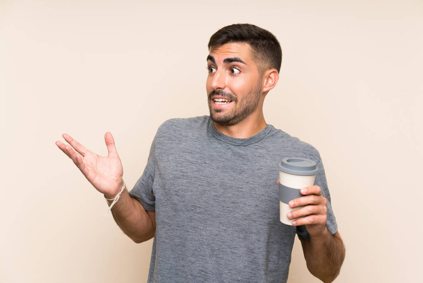 Красавчик с бородой уносит кофе на обособленном фоне с неожиданным выражением лица
 - Фото, изображение