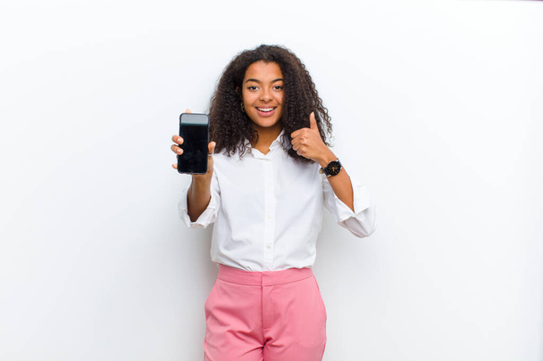 young pretty black woman with a smart telephone against white wall - Фото, зображення