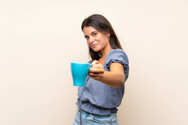 コーヒーの熱いカップを保持する孤立した背景の上の若い女の子 - 写真・画像