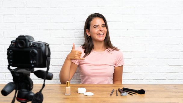 Young girl recording a video tutorial making phone gesture - Photo, Image