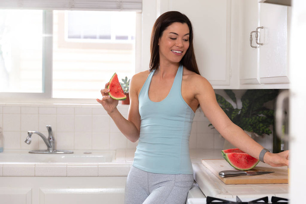 Fitness femenino y alimentación saludable estilo de vida retrato, sandía fruta comida antes o después del entrenamiento, en ropa deportiva
 - Foto, Imagen