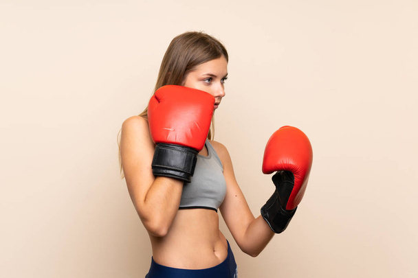 Mladá blondýna dívka s boxerskými rukavicemi přes izolované pozadí - Fotografie, Obrázek