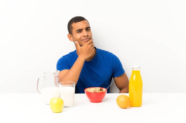 Young man having breakfast in a table thinking an idea - Photo, Image