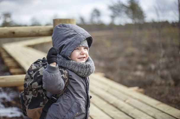 Ragazzino fare escursioni con lo zaino nella foresta in una giornata fredda
 - Foto, immagini
