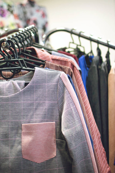 Красочная тенденция женские платья, брюки на вешалках в розничном магазине
,  - Фото, изображение