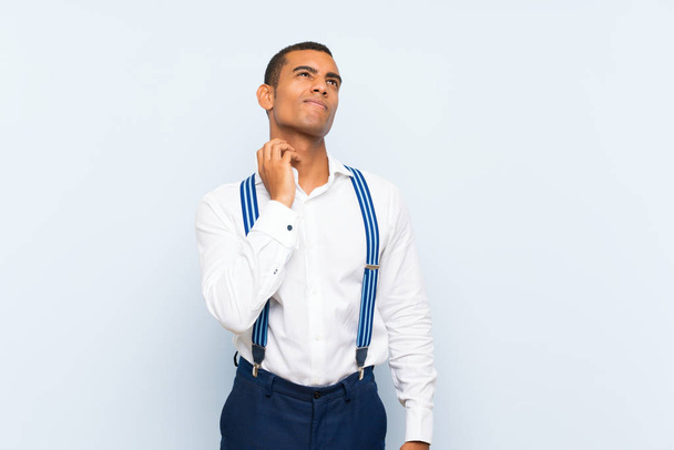 Young handsome brunette man with suspenders over isolated background thinking an idea - Foto, immagini