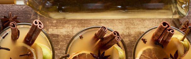 Geleneksel armut şarabının en üst görüntüsü. Bardakta, ahşap kırsal masada baharatlar, panoramik çekim. - Fotoğraf, Görsel
