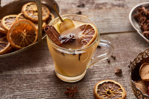 seasonal traditional pear mulled wine with spices in glass on wooden rustic table - Fotó, kép