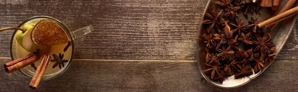 κορυφαία θέα του παραδοσιακού ζεστού αχλαδιού με μπαχαρικά και αποξηραμένα εσπεριδοειδή σε ξύλινο ρουστίκ τραπέζι, πανοραμική λήψη - Φωτογραφία, εικόνα