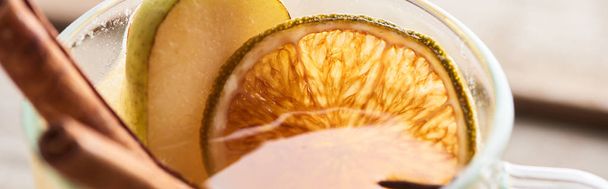 close up view of pear mulled wine with spices and dried citrus, panoramic shot - Fotoğraf, Görsel