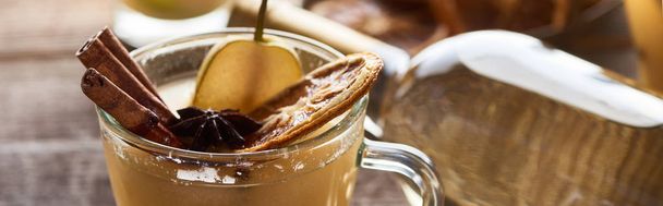 close up view of tasty pear mulled wine with spices and dried citrus, panoramic shot - Fotó, kép