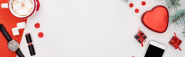 panoramisch shot van koffie met marshmallow, geschenkdozen, polshorloge, lippenstift, dennentak, smartphone, rood papier geïsoleerd op wit - Foto, afbeelding