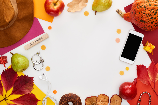 шляпа, смартфон, фрукты, тыква, сухие листья, разноцветные бумаги, пончики, зерна кофе, деревянный блок с октябрьской надписью изолированы на белом
 - Фото, изображение