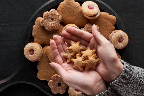 partial view of woman holding snowflake cookies in hands - Photo, image