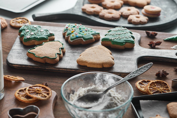 selective focus of baked Christmas cookies near ingredients on wooden table - Photo, Image