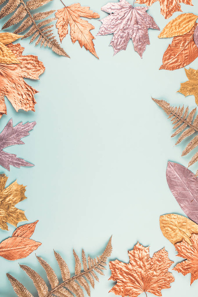 Autumn composition with golden leaves frame on blue pastel backg - Photo, Image