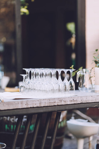 Clean empty wine glasses on wooden table in cafe. Glass goblets  - 写真・画像