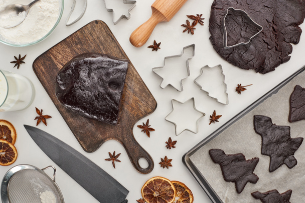 horní pohled na syrové těsto pro čokoládové vánoční cukroví v blízkosti složek na bílém pozadí - Fotografie, Obrázek