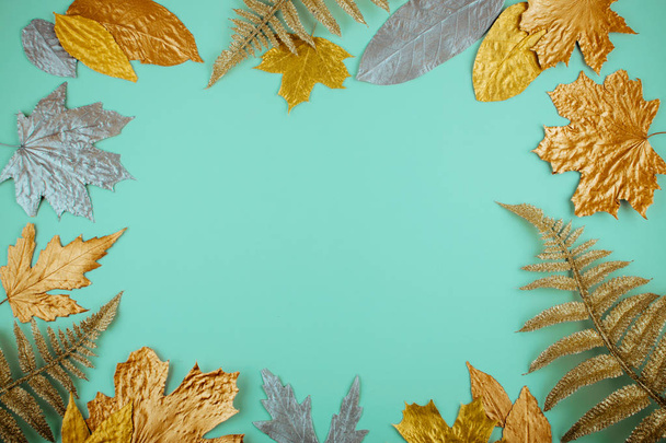 Composition d'automne avec cadre de feuilles dorées sur fond bleu menthe
 - Photo, image