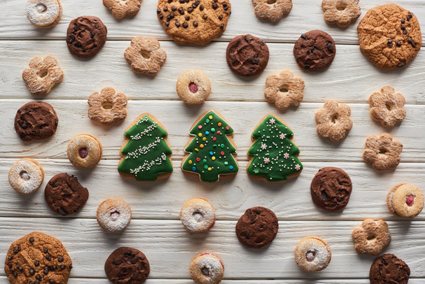 top view of Christmas tree cookies on wooden white table - Foto, imagen