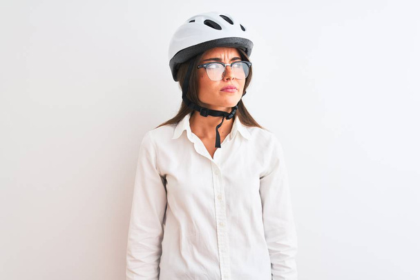 Beautiful businesswoman wearing glasses and bike helmet over isolated white background smiling looking to the side and staring away thinking. - Foto, Bild