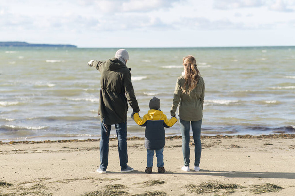 happy family at autumn beach looking at sea - Foto, imagen