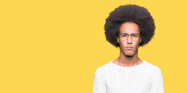 Young african american man with afro hair wearing glasses skeptic and nervous, frowning upset because of problem. Negative person. - 写真・画像