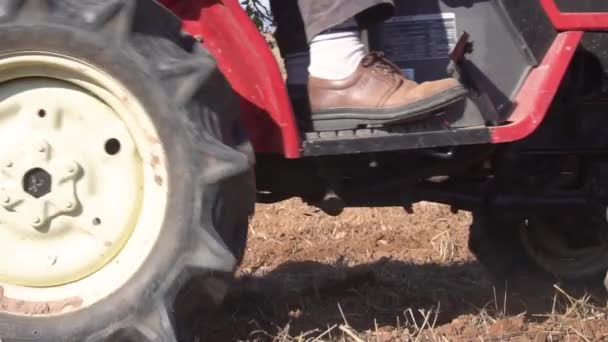 Roter Traktor mit Pflug pflügt Ackerboden aus nächster Nähe in Zeitlupe. - Filmmaterial, Video
