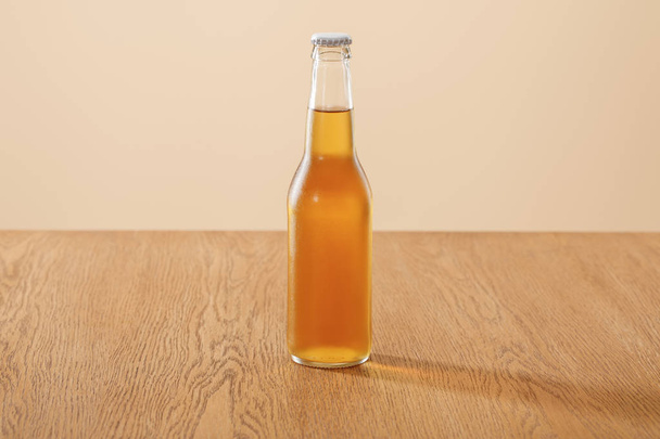 bouteille de bière à table en bois isolée sur beige
 - Photo, image