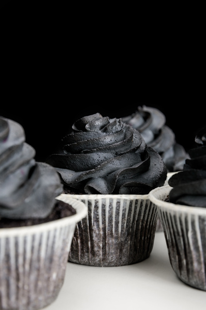 delicious Halloween cupcakes with black cream isolated on black - Foto, imagen