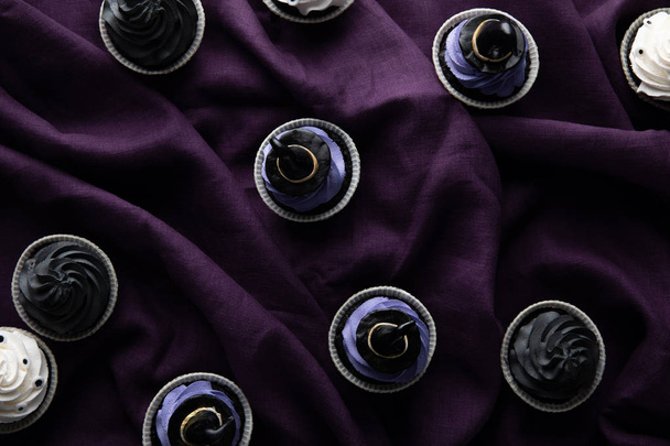 top view of delicious Halloween cupcakes on purple cloth - Foto, Imagem