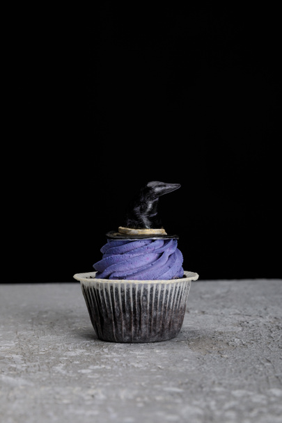 vynikající Halloween cupcakes s bílým krémem v blízkosti hořící svíčky izolované na černé - Fotografie, Obrázek
