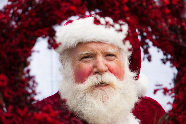 Santa kijken door rode krans - Foto, afbeelding