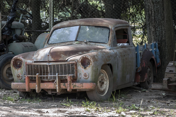 Imagen en stock de un coche viejo, oxidado y abandonado
. - Foto, Imagen
