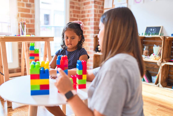 美しい先生と幼児の女の子遊びます建設ブロックbulding塔とともに幼稚園 - 写真・画像