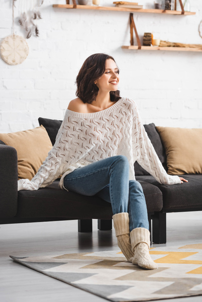 happy beautiful woman sitting on sofa in cozy living room  - Foto, Imagem