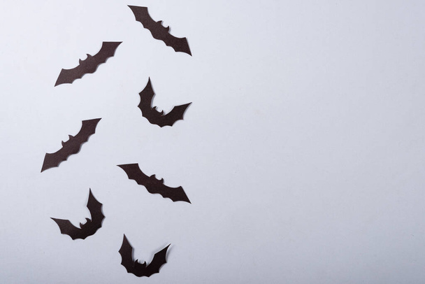 Halloween e concetto di decorazione, Pipistrelli di carta nera che sorvolano lo sfondo grigio
. - Foto, immagini