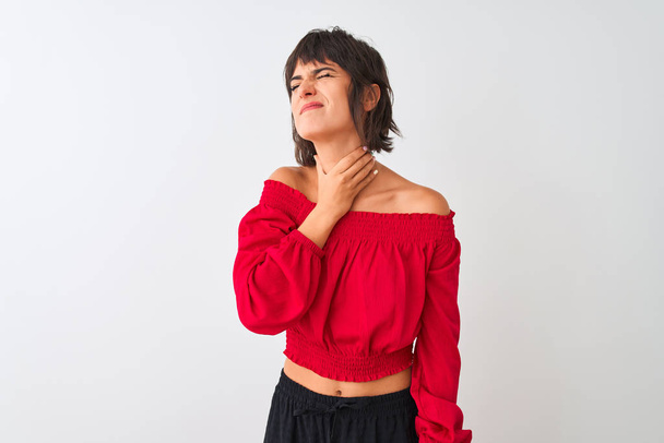 Молода красива жінка в червоній літній футболці, що стоїть над ізольованим білим тлом, торкаючись болючої шиї, болючого горла від грипу, клону та інфекції
 - Фото, зображення