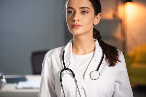houkutteleva lääkäri valkoisessa takissa stetoskoopilla yövuoron aikana
 - Valokuva, kuva