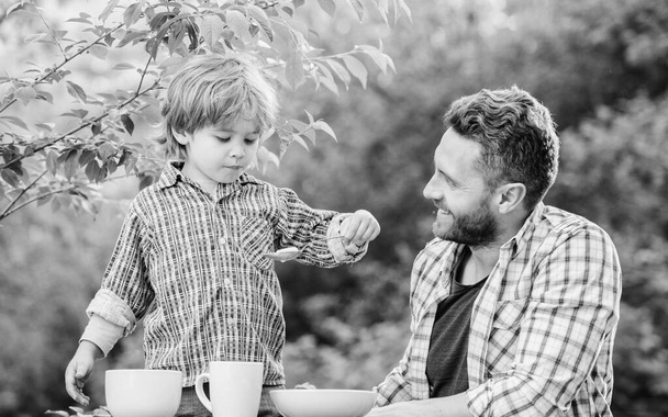 Little boy and dad eat. Organic nutrition. Healthy nutrition concept. Nutrition habits. Family enjoy homemade meal. Personal example. Nutrition kids and adults. Father teach son eat natural food - Foto, immagini