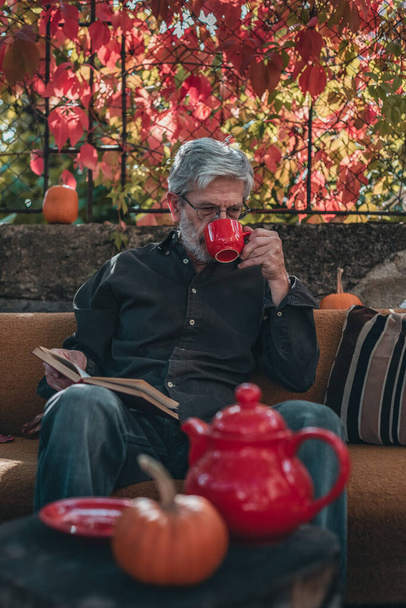 vieil homme boire du thé et lire un livre
 - Photo, image