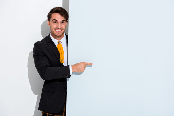 happy man in formal wear pointing with finger on white  - Foto, Imagen