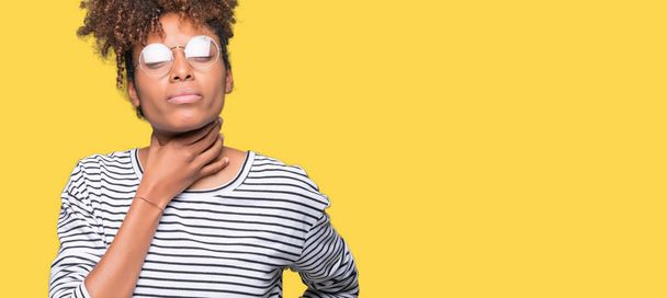 Beautiful young african american woman wearing glasses over isolated background Touching painful neck, sore throat for flu, clod and infection - Photo, Image